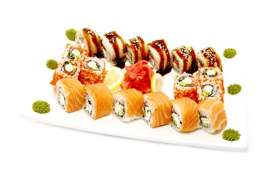 large plate of sushi with fruit and sauce