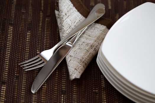 Table layout with tableware and a napkin on dark background