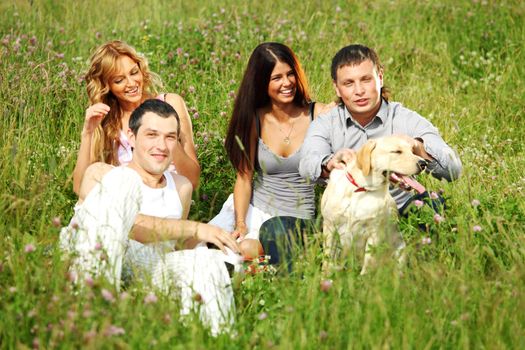 friends and dog in green grass field