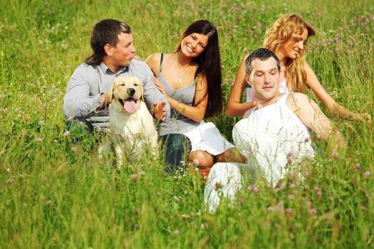 friends and dog in green grass field