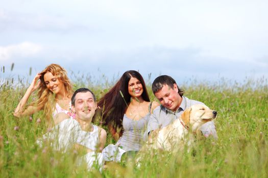 friends and dog in green grass field