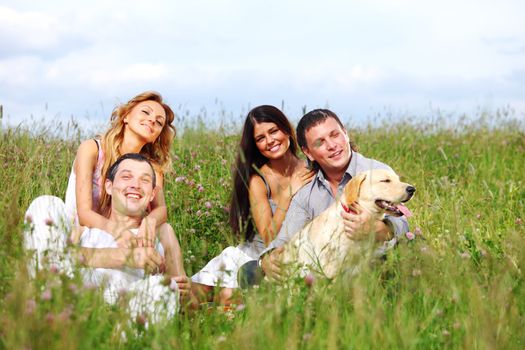 friends and dog in green grass field