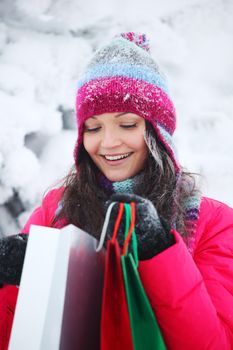 winter girl with gift bags on snow background