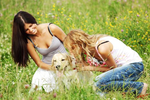 girlfriends and dog in green grass field