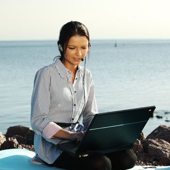 woman with laptop sea background