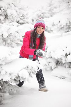 winter woman play snowballs on snow background