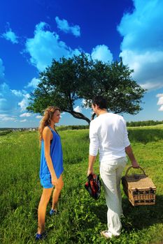 man and woman on picnic in green grass