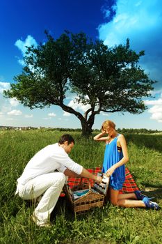 man and woman on picnic in green grass