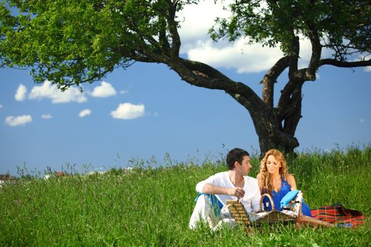 man and woman on picnic in green grass