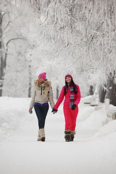 two winter women run by snow frosted alley