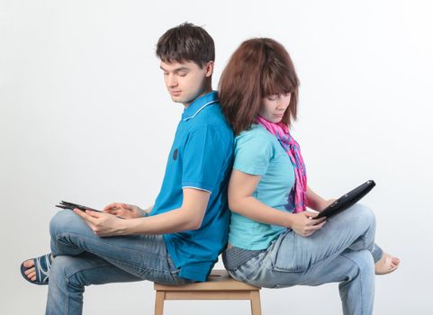 A young couple with a Tablet PC, on gray background