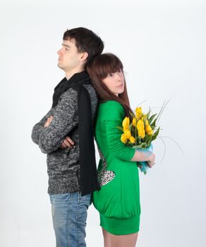 happy young couple with bouquet flowers, on gray background