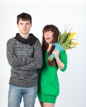 happy young couple with bouquet flowers, on gray background