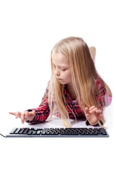 a little girl writes on the PC keyboard