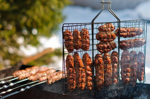 Cooking sausages on grill in the brazier at winter park