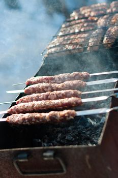 Cooking sausages on skewers in the brazier at winter park