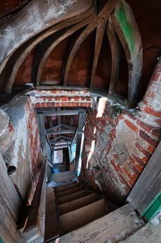 Stairs in abandoned church brick tunnel with wooden ceiling