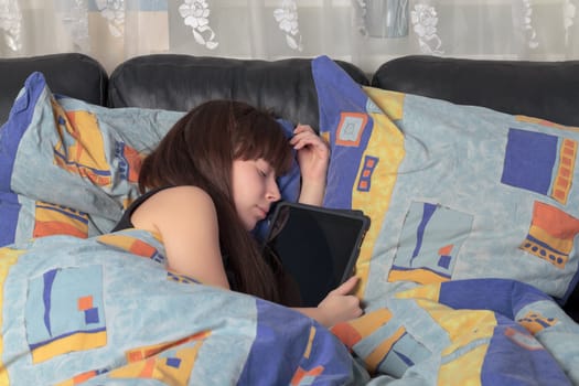 a young girl asleep in an embrace with a tablet laptop