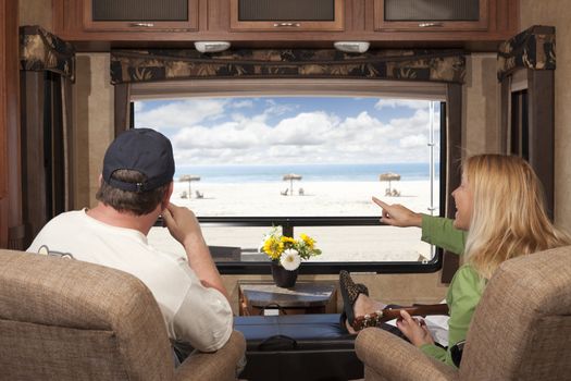 Young Couple Enjoying the Beach View From Their 5th Wheel RV.
