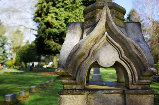 Asian Stone or concrete design statue with green trees and grass in background