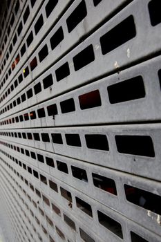 Black and white image of a perforated metal garage door in dimishing perspective