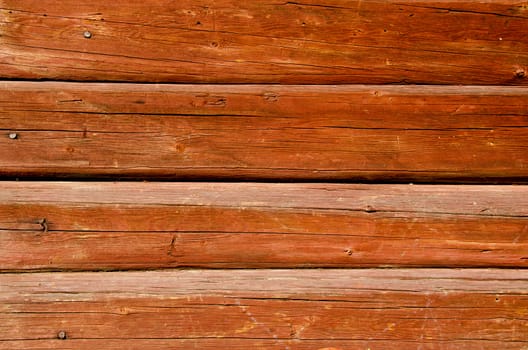 Background of ancient shaved painted wooden log wall and rusty nail heads.