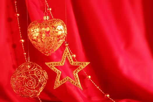 Golden christmas decoration on red fabric background