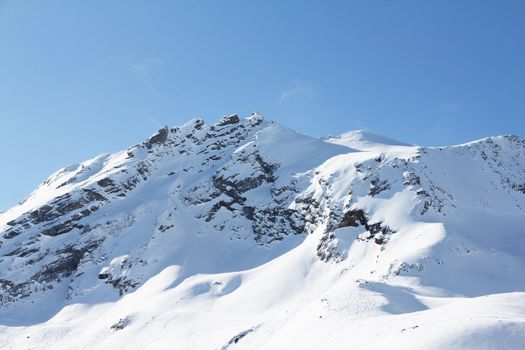 Mountain peaks of winter alps under blue sky