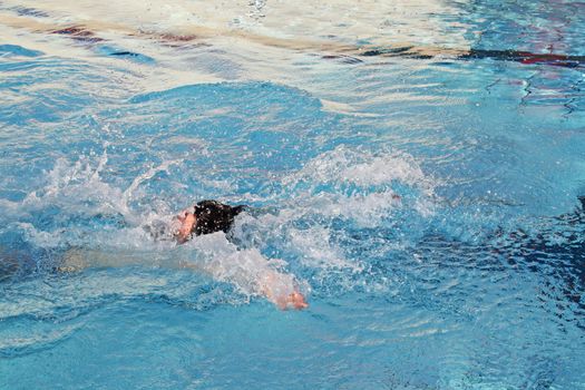 man swims in swimming pool