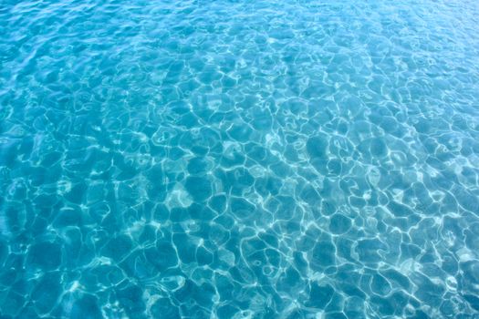 Background of transparent blue sea water top view