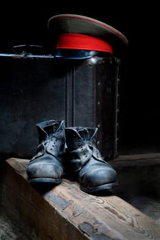 Stock photo: an image of old black boots, a hat and a suitcase