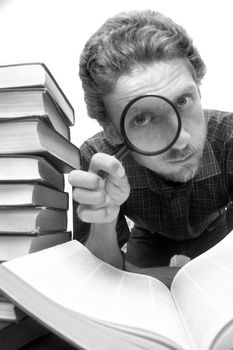 A man sitting amongst books with a magnifier