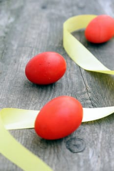 An image of three red eggs and a yellow stripe