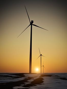 Wind turbines on hill at sunset