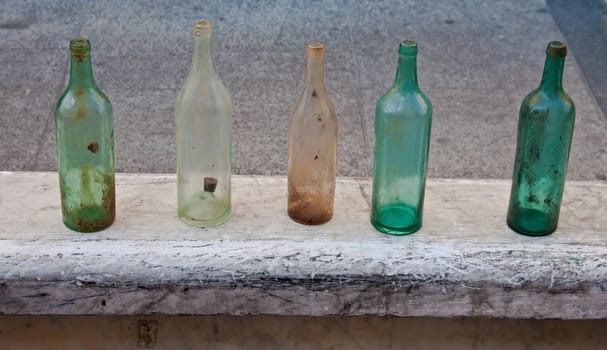 five old dirty bottles in one row