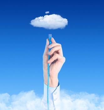 Hand with the cable connected to the cloud. Conceptual image on cloud computing theme.