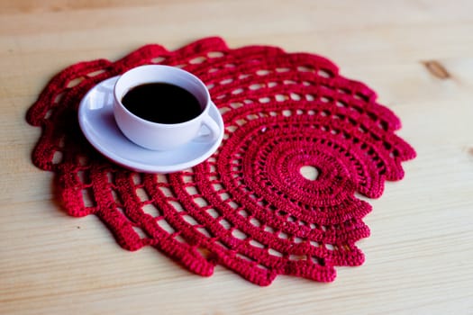 A coffee cup on red napkin on wooden table
