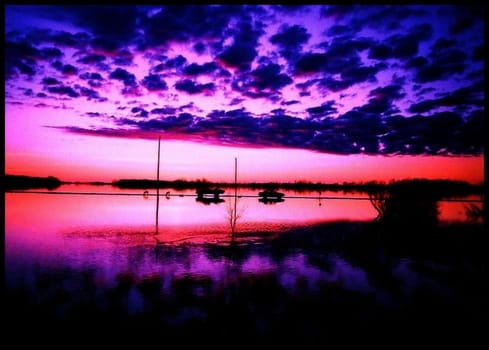 Dangerously beautiful sunset over a flooded country field.