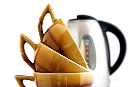 Three brown cups and kettle on a white background
