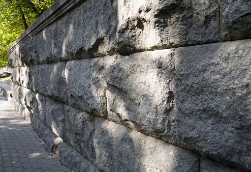 Old granite stone wall in city park