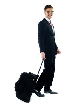 Corporate person leaving for business meeting as he drags his luggage