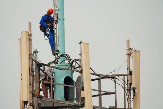 Workmen performing their duties high on a communisations tower