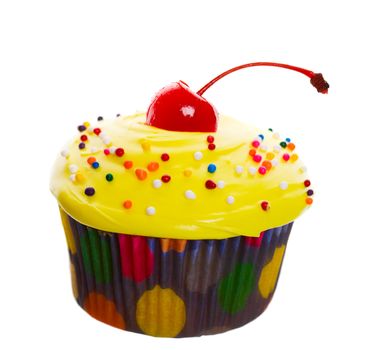 Delectable yellow cupcake topped with a cherry and multi-colored sprinkles.  Shot on white background.