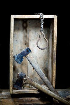 Stock photo: an image of two axes and metal chain  in a wooden box