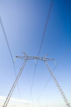 High voltage pylons on the background  of  blue  cloudless  sky

