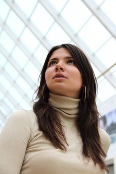 Portrait of beautiful brunette looking up in modern interior