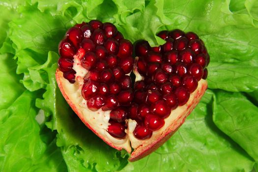 Pomegranate heart on lettuce concept of healthy eating