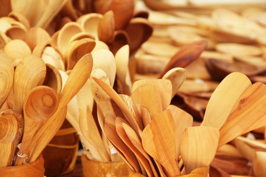 Many wooden handmade spoons close-up background