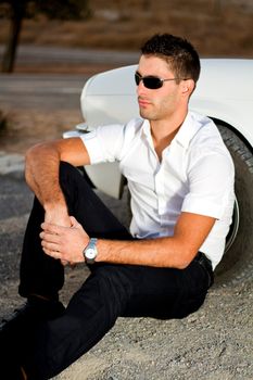 View of a young male next to his white convertible car.