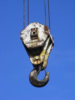 photo of a crane hook isolated against a blue sky background